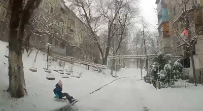 (VIDEO) Părinți iresponsabili? O copilă a fost la un pas să fie strivită de o mașină în timp ce se dădea cu sania - Photo